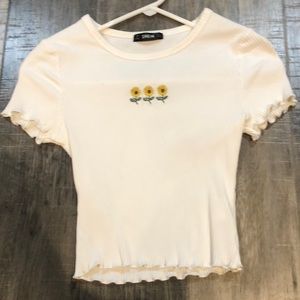 White crop top with three sunflowers across the chest.